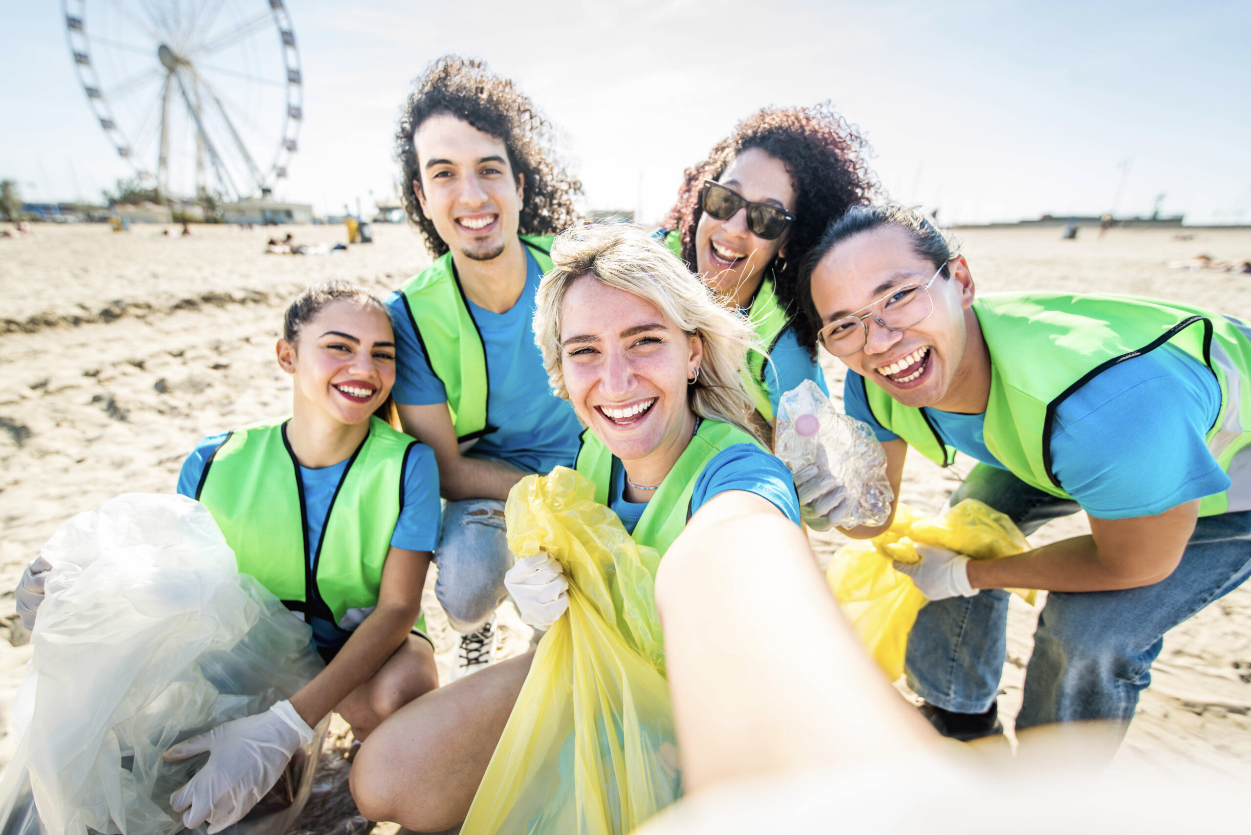 Group of eco volunteers picking up plastic trash on the beach -