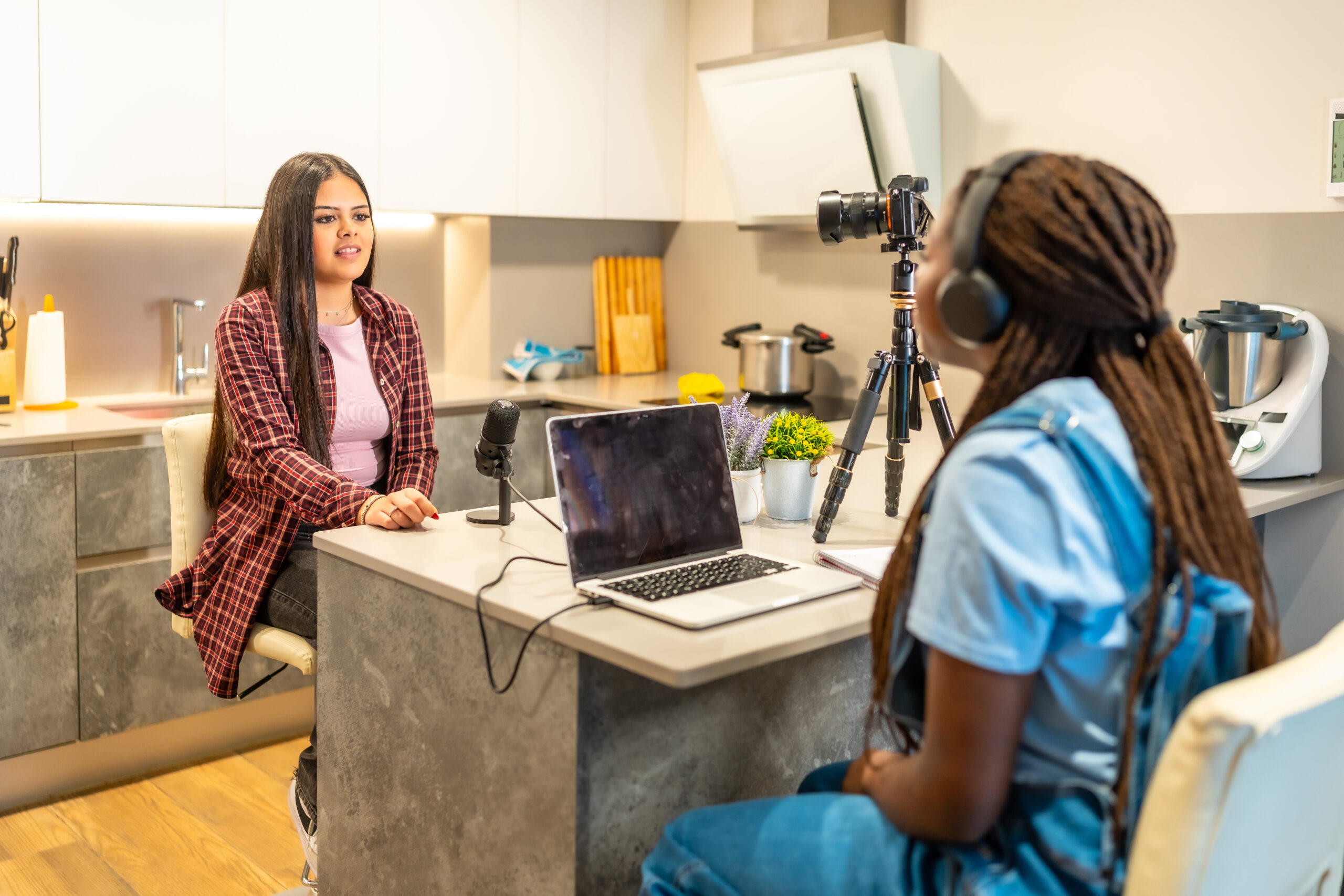 Two young content creators recording a podcast in a modern kitchen